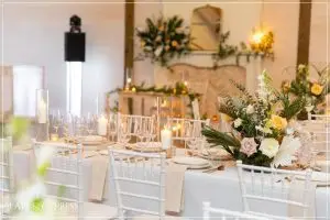 Long elegantly set wedding reception table with floral centerpieces