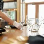 Staff member arranging wine glasses for an event